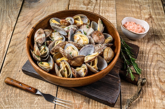 Coquilles cuites à la vapeur Palourdes vongole dans une assiette en bois