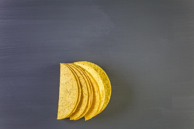 Coquilles de tacos de maïs jaune sur fond gris.