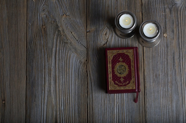 Coran et bougies sur une surface en bois Traduction en anglais le livre contient des versets du Coran