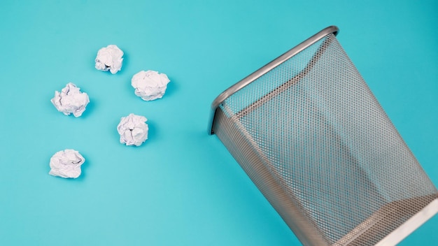 Corbeille remplie de papier isolé sur fond bleu