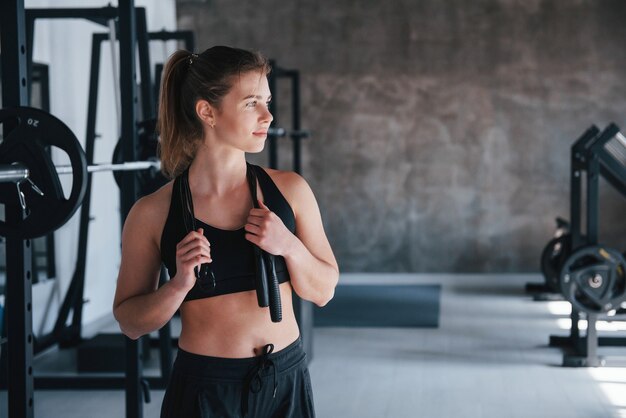 Corde à sauter de couleur noire. magnifique femme blonde dans la salle de gym pendant son week-end.