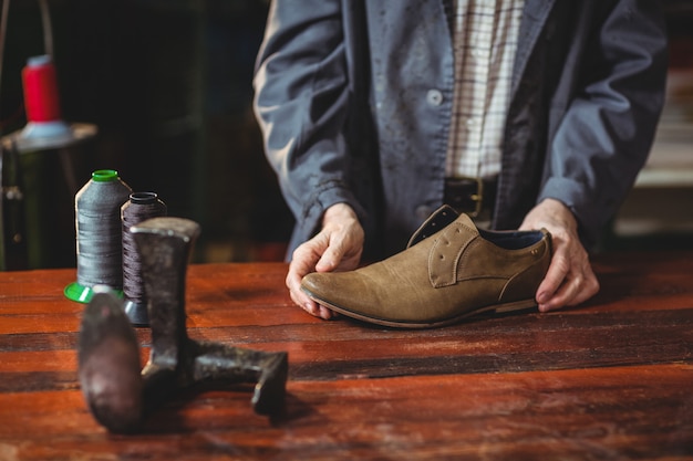 Cordonnier examinant une chaussure