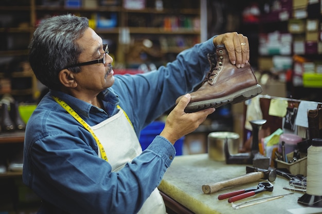 Cordonnier examinant une chaussure