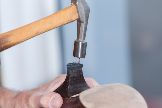 Le cordonnier répare une chaussure