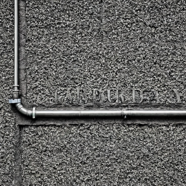 Photo la cornemuse écrite en peinture noire sur un mur de béton gris