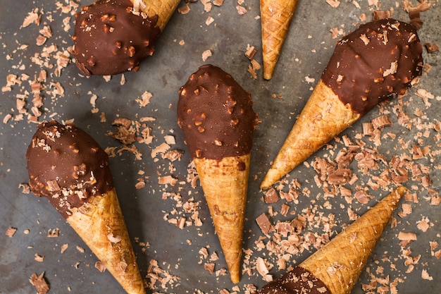 Cornets de crème glacée au chocolat avec des pépites d'amande sur une table en métal en vue de dessus