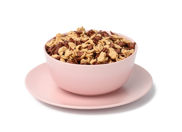 Cornflakes au chocolat et au miel en plaque rose sur fond blanc. Petit déjeuner du matin avec du lait