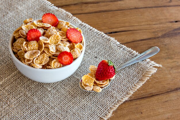 Cornflakes au lait et morceaux de fraise, petit-déjeuner sain.