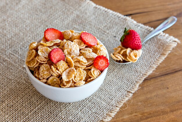 Cornflakes au lait et morceaux de fraise, petit-déjeuner sain.