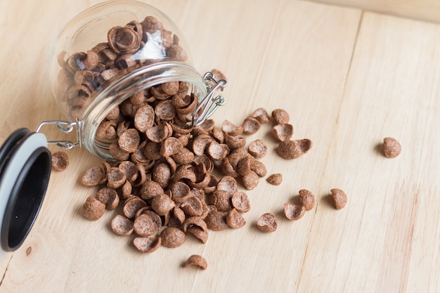 Cornflakes de céréales au chocolat se répandant à la surface du bois