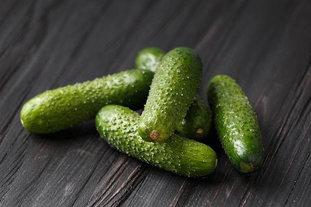 Cornichons crus sur un gros plan de fond en bois foncé