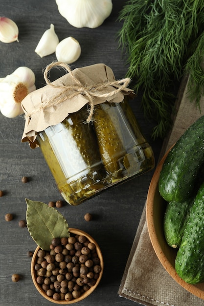 Cornichons et ingrédients frais sur une table en bois foncé