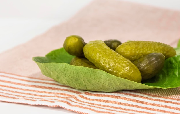 Cornichons marinés croustillants sur une feuille de laitue verte sur la table