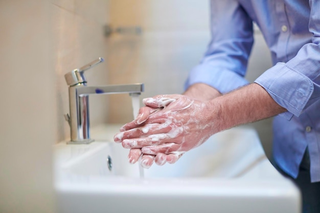 Coronavirus mâle se laver les mains dans la salle de bain