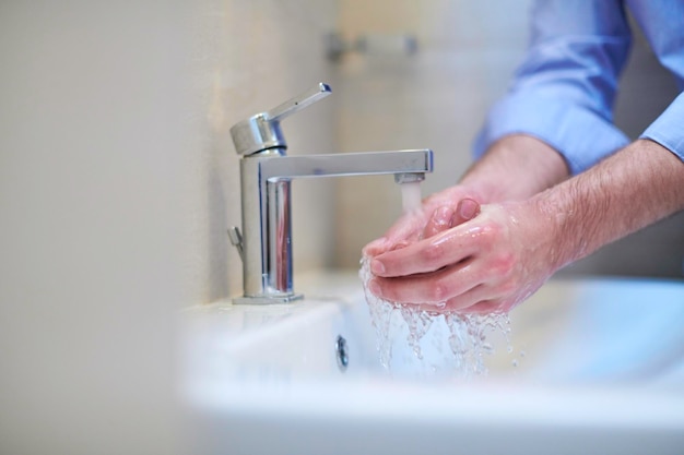 Coronavirus mâle se laver les mains dans la salle de bain