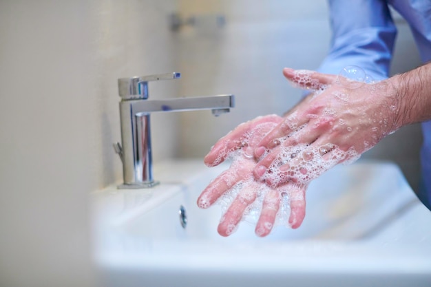 Coronavirus mâle se laver les mains dans la salle de bain