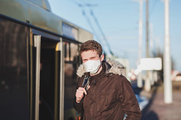 Coronavirus pandémique COVID-19 une personne dans un lieu public. Jeune homme portant un masque de protection. Protection contre les coronavirus