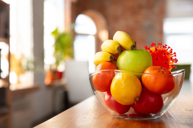 Le coronavirus se cache dans les choses habituelles - vérifiez le nettoyage et la fraîcheur de vos fruits et de vos aliments. L'un des groupes. Pommes, oranges, citrons sur la table de la cuisine. Pandémie, concept épidémique, désinfection.