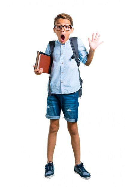 Corps entier du garçon étudiant avec sac à dos et lunettes avec surprise et choqué.