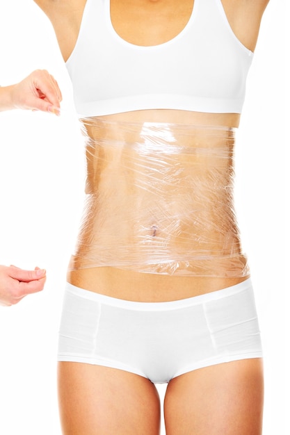 un corps féminin sexy enroulé autour de papier d'aluminium pour réduire la graisse sur fond blanc
