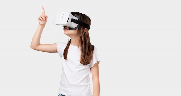 Corps plein petite fille excitée et divertie, jouant avec des lunettes de réalité virtuelle