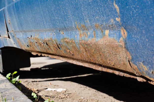 Corrosion sévère sur la vieille voiture bleue. Une vieille voiture rouillée