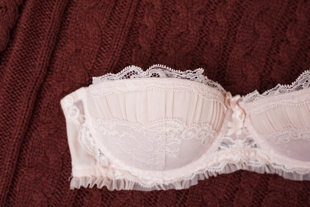 Corsage en dentelle beige sur un pull tricoté.