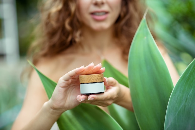 Cosmétique bio. Gros plan d'une femme tenant un pot de crème pour le visage