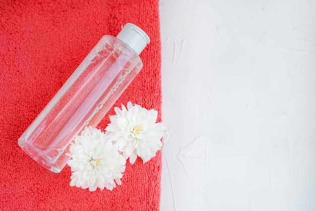 Cosmétique pour le visage et une serviette sur un fond blanc. Vue de dessus. Le c