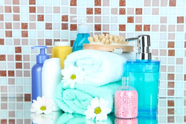 Cosmétiques et accessoires de bain sur fond de carreaux de mosaïque