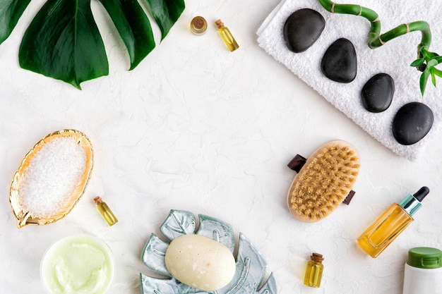 Cosmétiques de beauté spa de bouteille, feuille de palmier, savon bio, pinceau sur tableau blanc