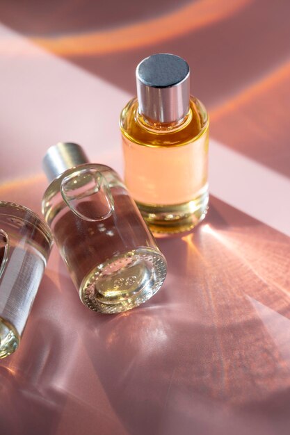 Cosmétiques de bouteille en verre avec de l'huile pour la beauté ou les soins de la peau sur fond rose lumière naturelle du soleil et nuances vue de dessus