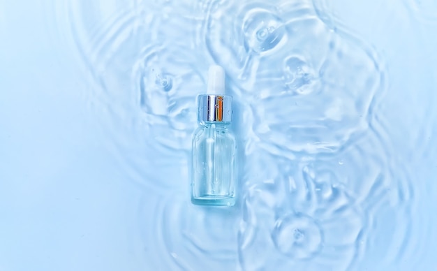 Photo cosmétiques dans une bouteille dans l'eau, concept d'hydratation de la peau. acide hyaluronique. mise au point sélective. la nature.