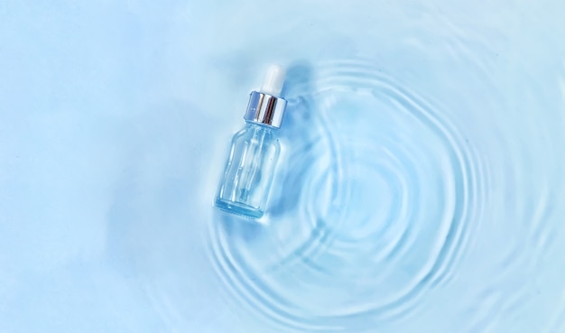 Cosmétiques dans une bouteille dans l'eau, concept d'hydratation de la peau. Acide hyaluronique. Mise au point sélective. La nature.