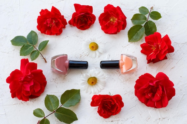 Cosmétiques femme avec des fleurs sur fond blanc