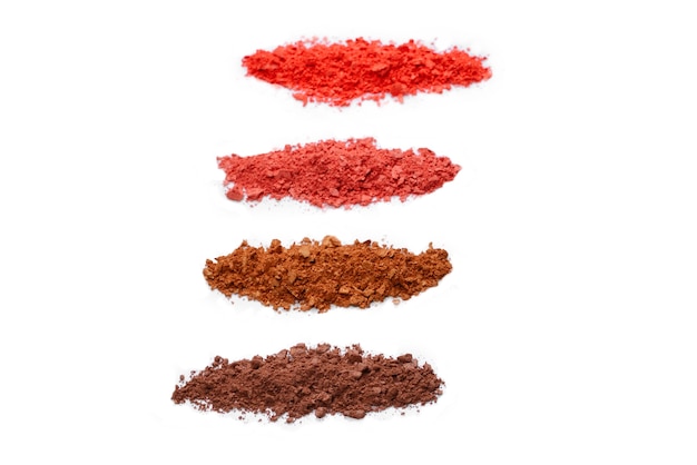 Cosmétiques de maquillage. Ombre à paupières dans la palette écrasée de couleurs brunes et rouges, poudre colorée d'ombre à paupières sur le fond blanc