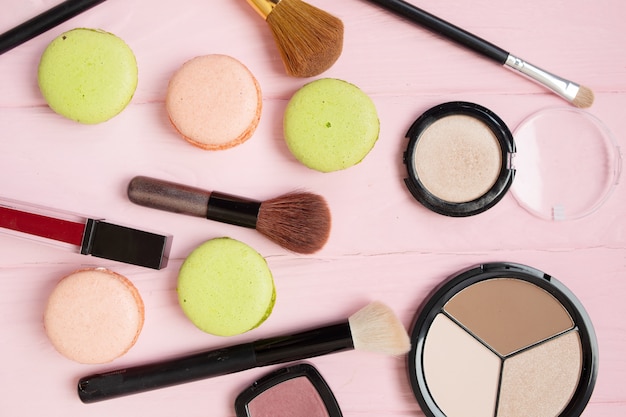 Cosmétiques de maquillage, pinceaux et autres essentiels. Vue de dessus, pose à plat. Collection d'outils et de produits de beauté multicolores, rouges à lèvres, fards à paupières, mascara et plus