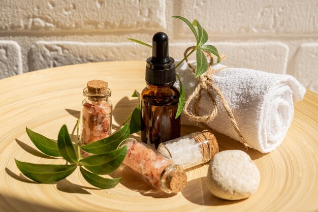 Cosmétiques naturels emballés dans un emballage respectueux de l'environnement dans une plaque de bambou avec une serviette de coton Produits de beauté pour bain SPA