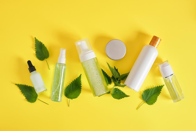 Cosmétiques naturels à l'extrait d'ortie, concept de soins de la peau et des cheveux, bouteilles maquettes et produits écologiques pour les soins personnels