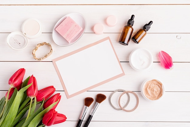 Cosmétiques De Printemps Et De Beauté. Vue De Dessus Des Cosmétiques Avec Des Tulipes Roses Vue De Dessus à Plat Sur Fond De Bois Blanc, Pose à Plat