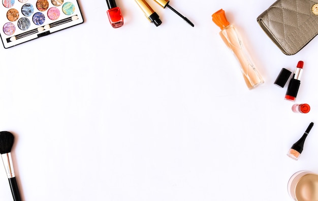 Cosmétiques professionnels et pinceaux de maquillage fond blanc. Plat poser. Vue de dessus