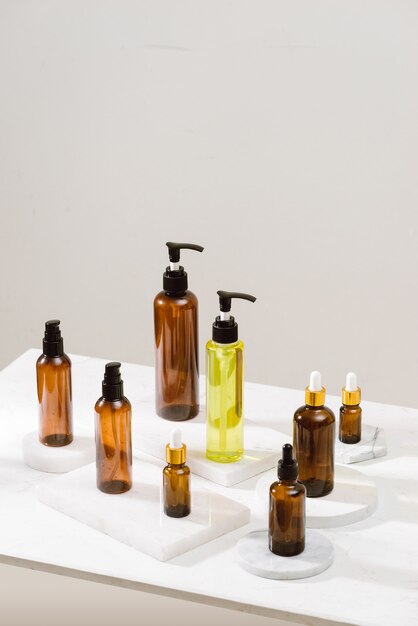 Cosmétiques de spa dans des bouteilles en verre marron sur une table en béton gris. Copiez l'espace pour le texte. Blogueuse beauté, thérapie de salon, maquette de marque, concept de minimalisme