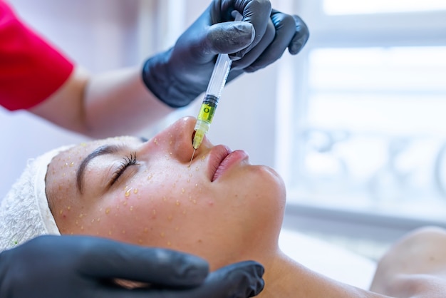 Photo cosmétologie du matériel, mésothérapie, portrait de jeune femme se faisant traiter la zone du front