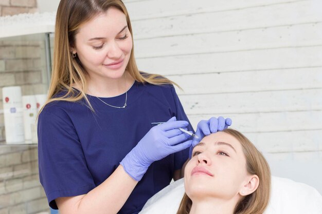 Photo le cosmetologist donne des injections à la fille