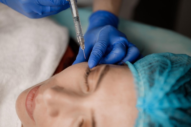 Un cosmetologist injecte une seringue dans un patient