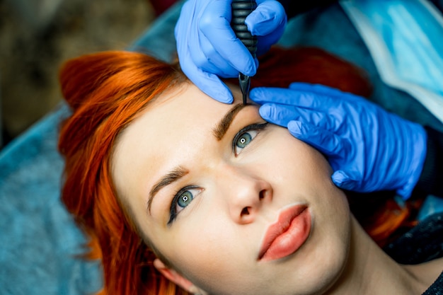 Cosmétologue application maquillage permanent sur les sourcils - tatouage des sourcils