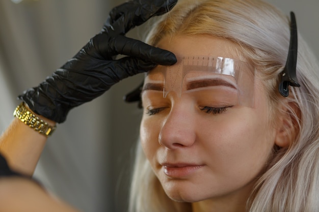 Cosmétologue appliquant un maquillage permanent sur les sourcils-tatouage des sourcils, règle