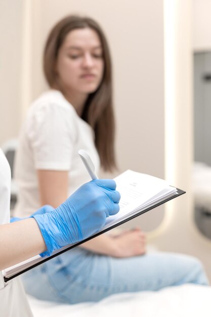 Photo un cosmétologue consulte une femme avant un traitement du visage