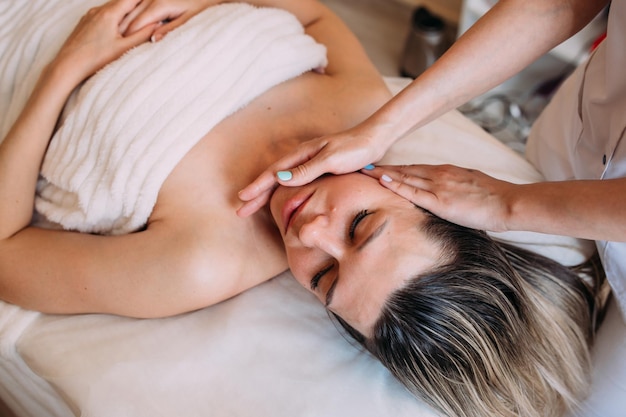 La cosmétologue fait des massages faciaux pour la beauté de la femme.