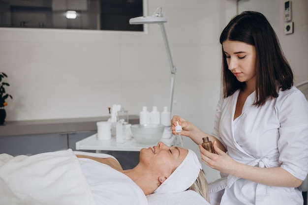 Photo une cosmétologue féminine tient une pipette avec de l'huile essentielle avant l'aromathérapie et le massage au patient aromathérapiecloseup